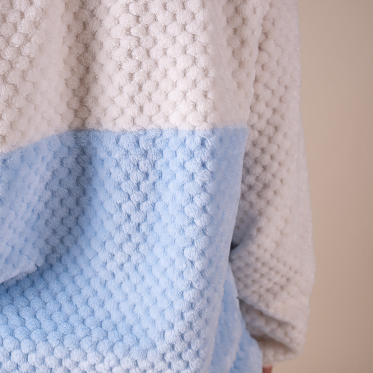 Close-up of a textured blanket with white and blue sections.