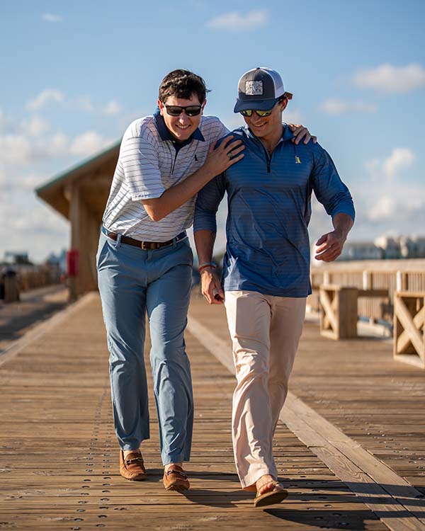 two men walking down a dock in local boy apparel