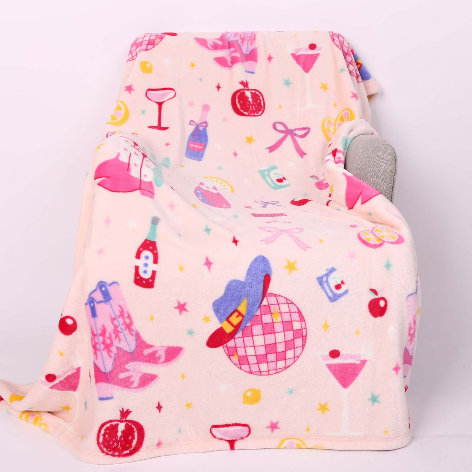 Disco cowgirl theme printed blanket laid out on a chair.