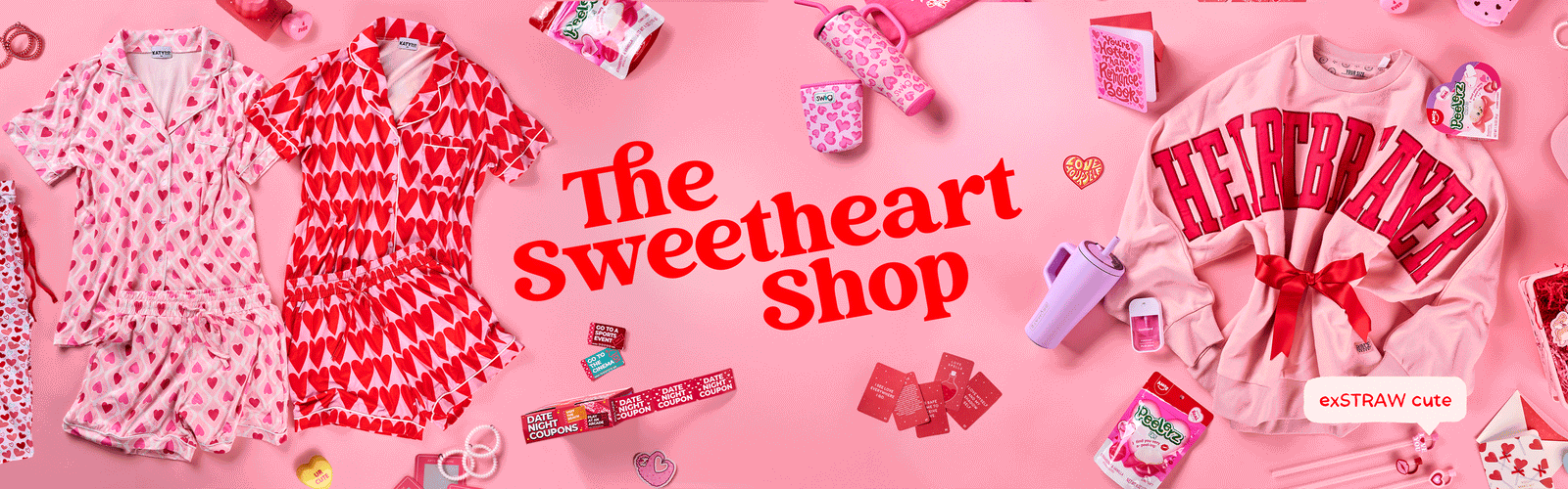 Valentine’s-themed hero banner featuring heart-print pajama sets, pink drinkware, candy, gift items, and a pink crewneck sweatshirt arranged on a blush background with the text “The Sweetheart Shop.”