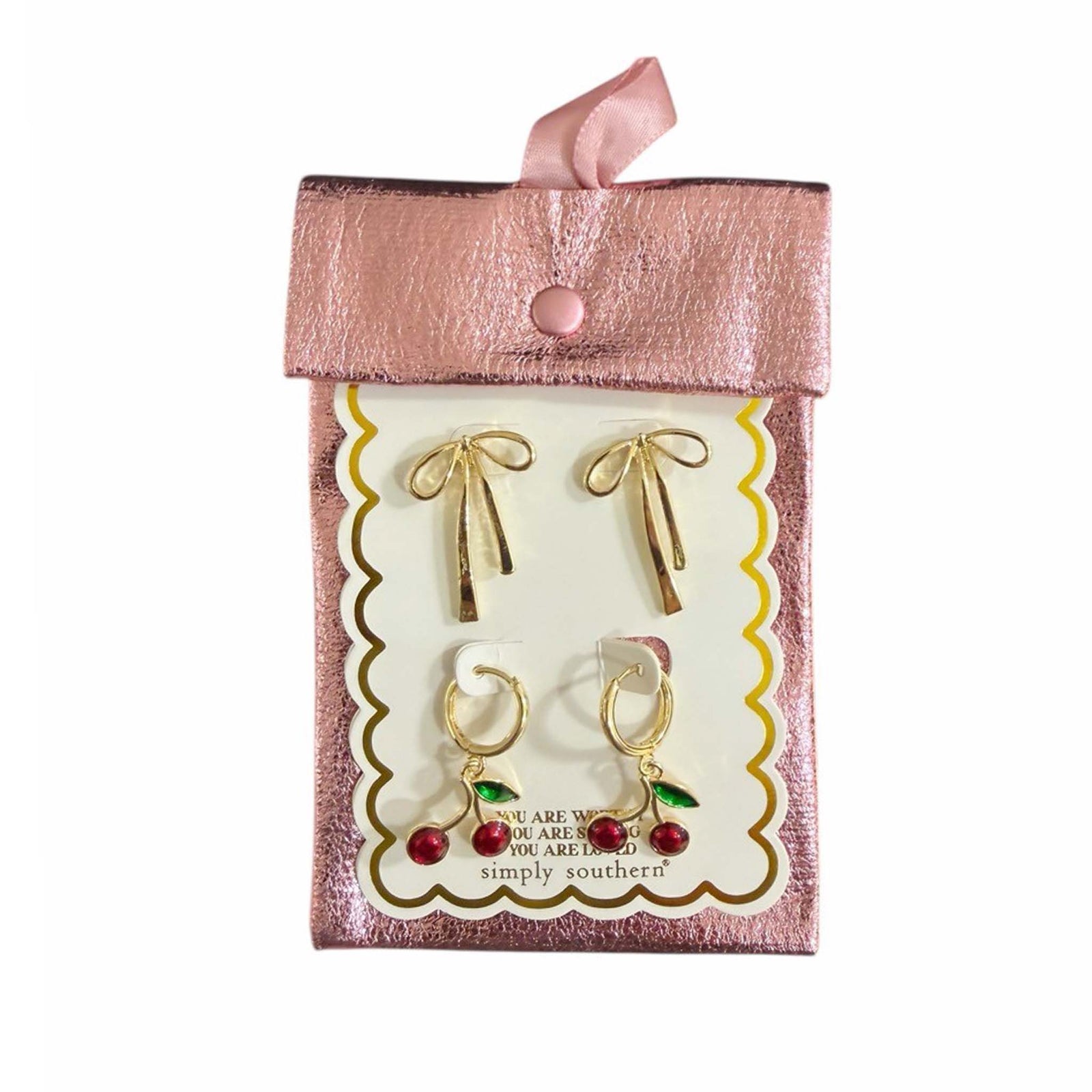 Gold bow drop earrings and cherry hoop earrings packaged in a pink Simply Southern pouch.