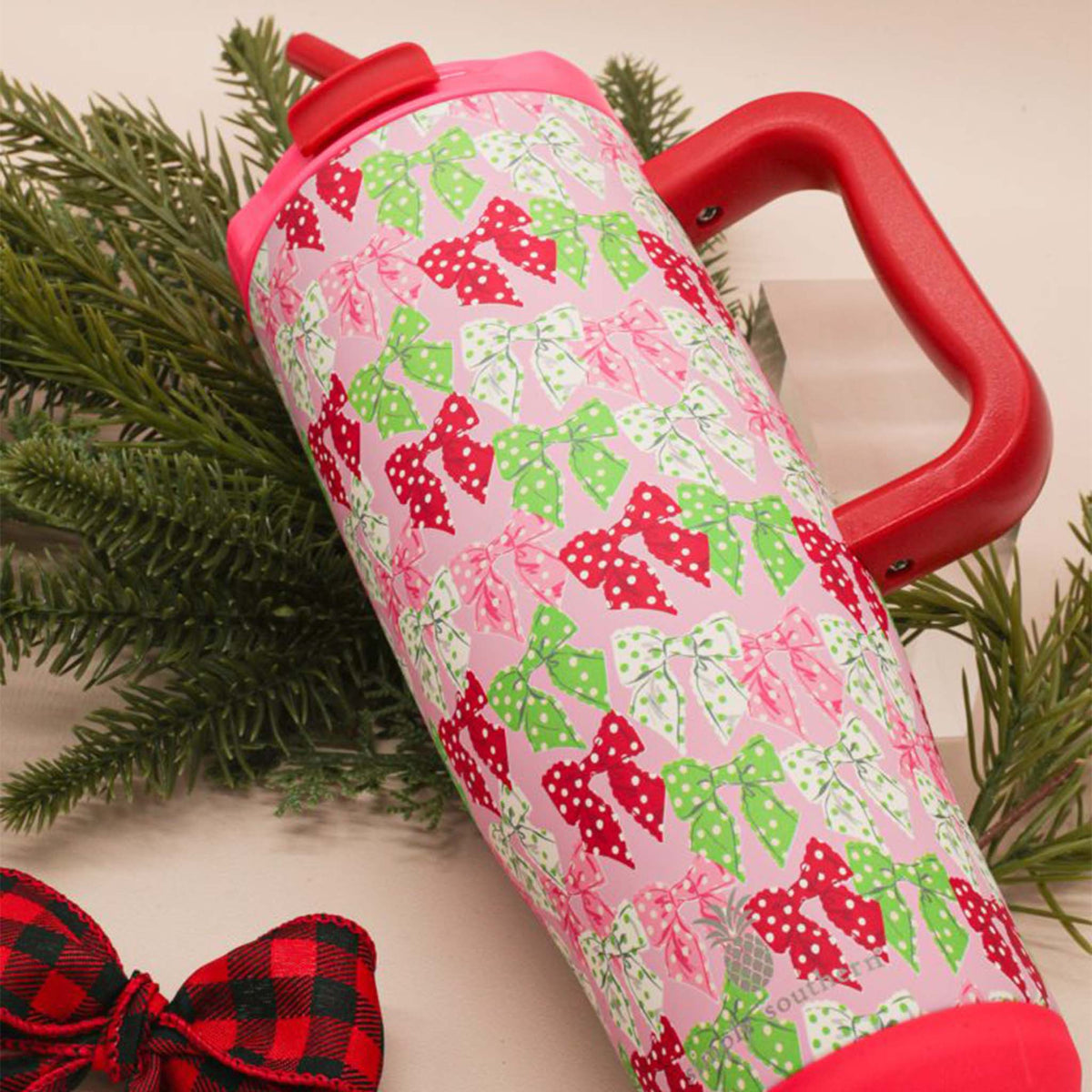 Simply Southern 40oz tumbler with festive red and green polka dot bows beside evergreen branches and a plaid bow.