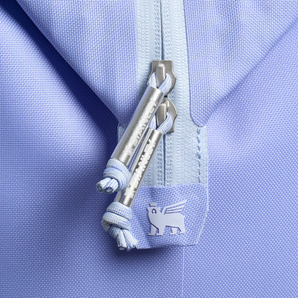 The cooler features a soft purple exterior, adjustable padded backpack straps, a front zippered pocket, and a top handle. Designed for portability and insulation, it is photographed in a studio with a neutral background.