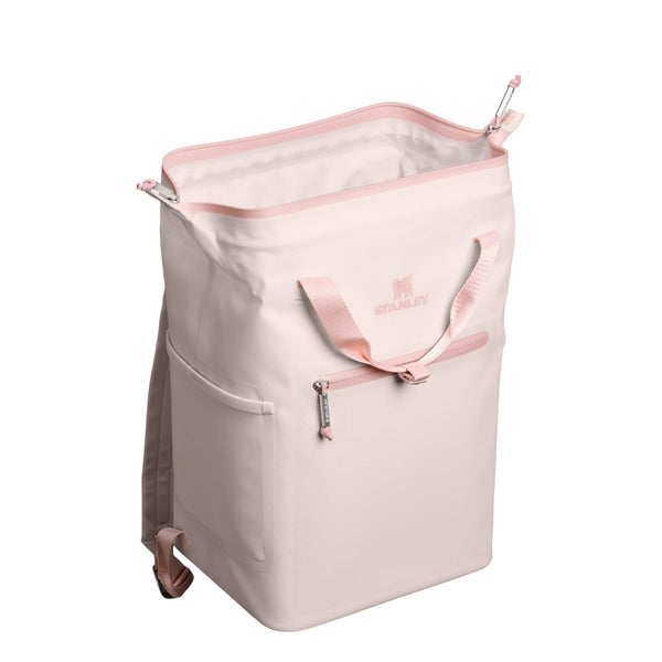 Stanley Madeline Mini Backpack Cooler in Rose Quartz shown standing upright. The compact cooler features a soft pink exterior, adjustable padded backpack straps, a front zippered pocket, and a top carry handle. Designed for lightweight portability and insulation.