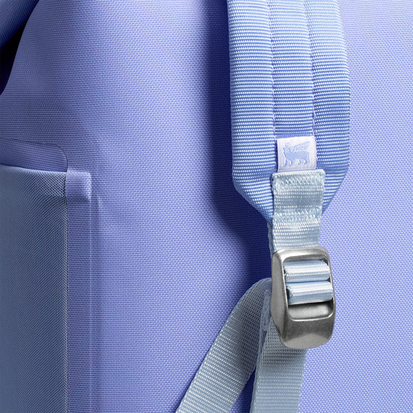 The cooler features a light lavender-purple exterior, adjustable padded backpack straps, a front zippered pocket, and a top carry handle.