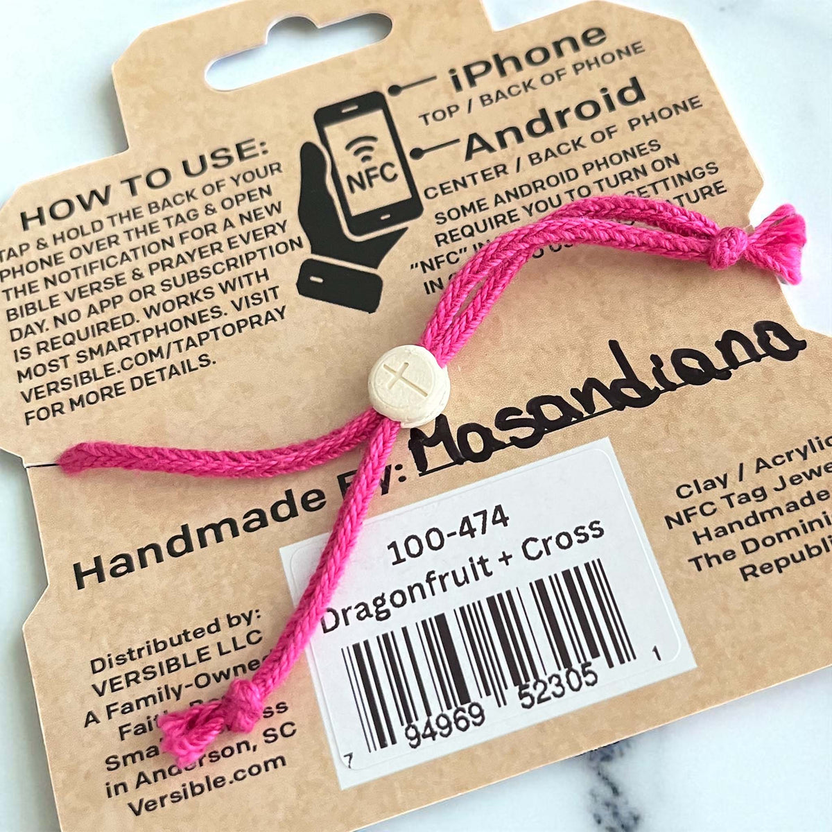 Back of Tap to Pray Survivor Series bracelet packaging showing adjustable pink braided cord, barcode, and product details “Dragonfruit + Cross.”