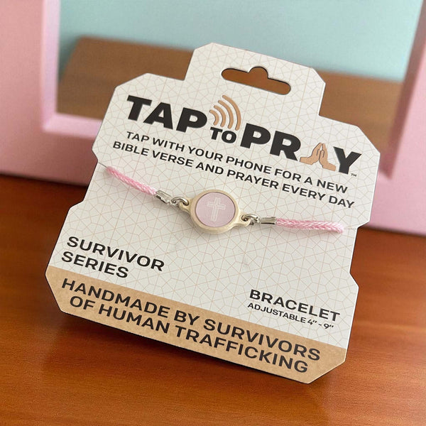 Bracelet on a 'Tap to Pray' packaging with text about prayer and human trafficking survivors.