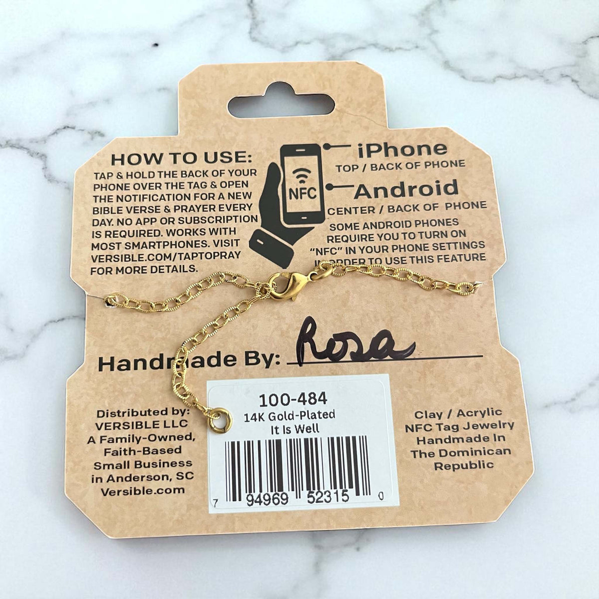 Gold necklace on a VERSIBLE branded card with instructions and product details.