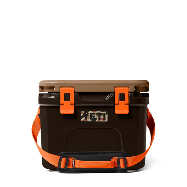 Front view of the YETI Roadie 15 Hard Cooler in Wetlands Camo showing carry strap and camo YETI logo.
