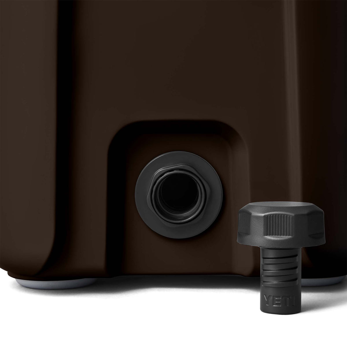 Close-up of screw cap drain plug on bottom corner of the cooler with removable black YETI plug.