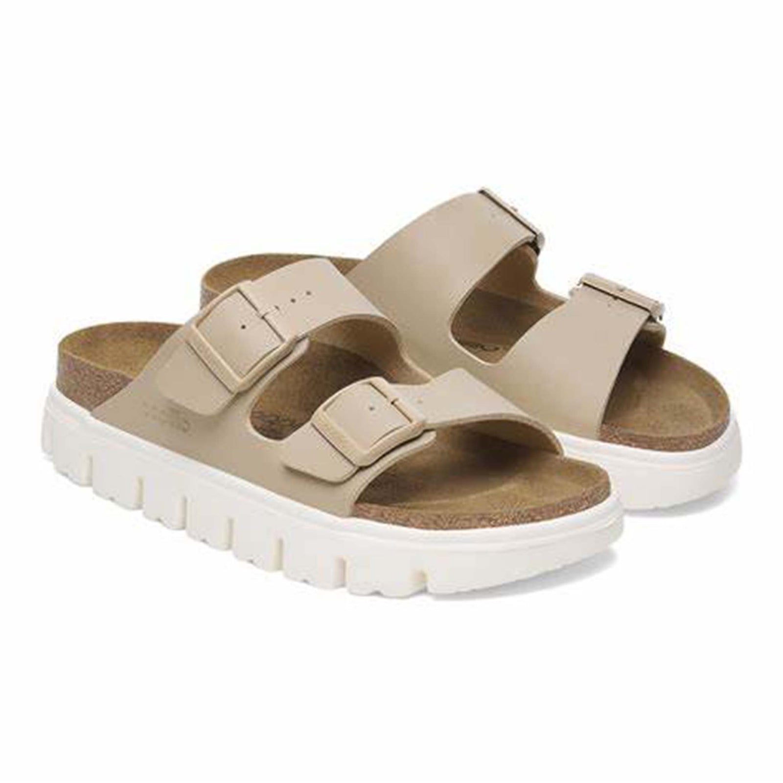 Birkenstock Arizona Chunky Sandals in Sandcastle, sizes 5/36, 6/37, 7/38, 8/39, 9/40, 10/41, 11/42. Quarter angle view of a pair of sandals showcasing their light tan straps, cork footbed, and chunky white outsole.