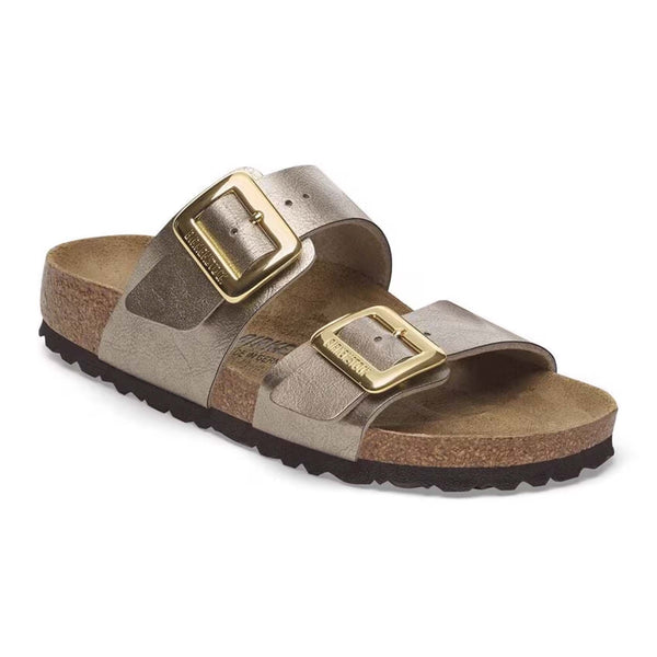 Birkenstock Sydney Luxe Buckle Sandals in Taupe, sizes 5/36, 6/37, 7/38, 8/39, 9/40, 10/41, 11/42. One sandal displayed at an angle with crisp detail on the dual straps, gold hardware, and cork footbed.