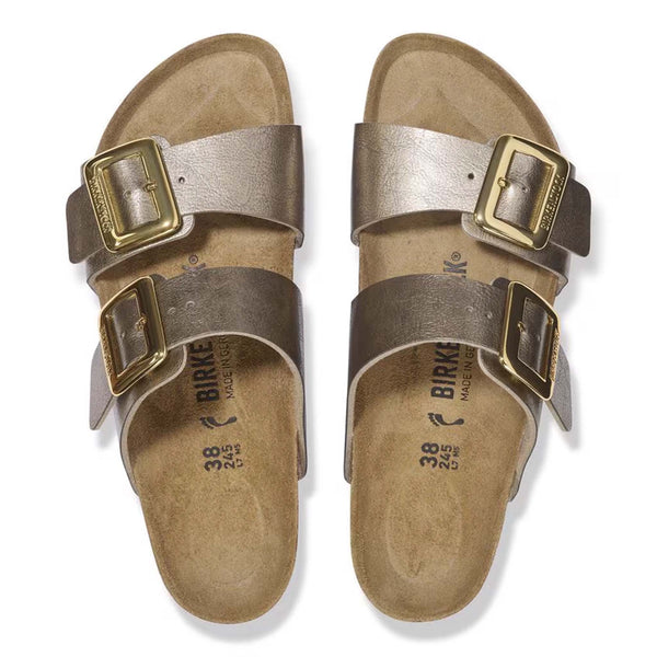 Birkenstock Sydney Luxe Buckle Sandals in Taupe, sizes 5/36, 6/37, 7/38, 8/39, 9/40, 10/41, 11/42. Overhead view of both sandals with metallic taupe straps, gold buckles, and tan footbeds on a white background.