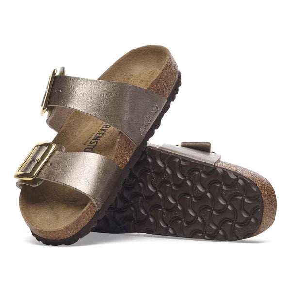 Birkenstock Sydney Luxe Buckle Sandals in Taupe, sizes 5/36, 6/37, 7/38, 8/39, 9/40, 10/41, 11/42. Side view of one sandal resting on the other, showing the textured black sole and cork footbed.