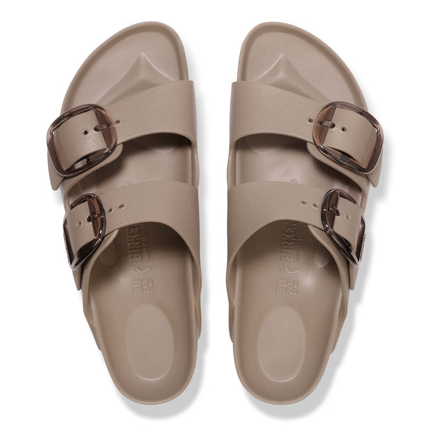 Pair of beige sandals with double buckles on a white background