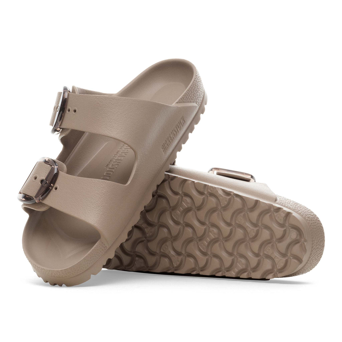 Pair of beige sandals with a buckle on a white background