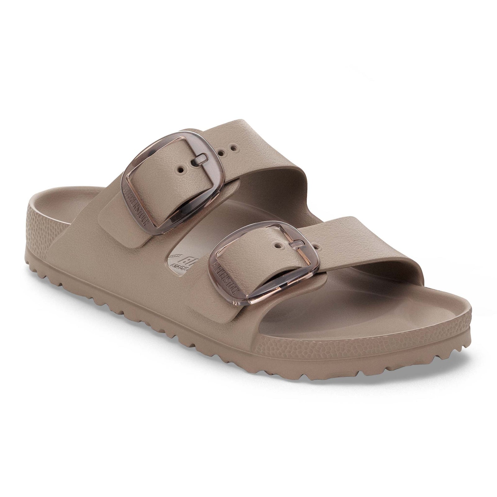 Tan sandal with two buckles on a white background