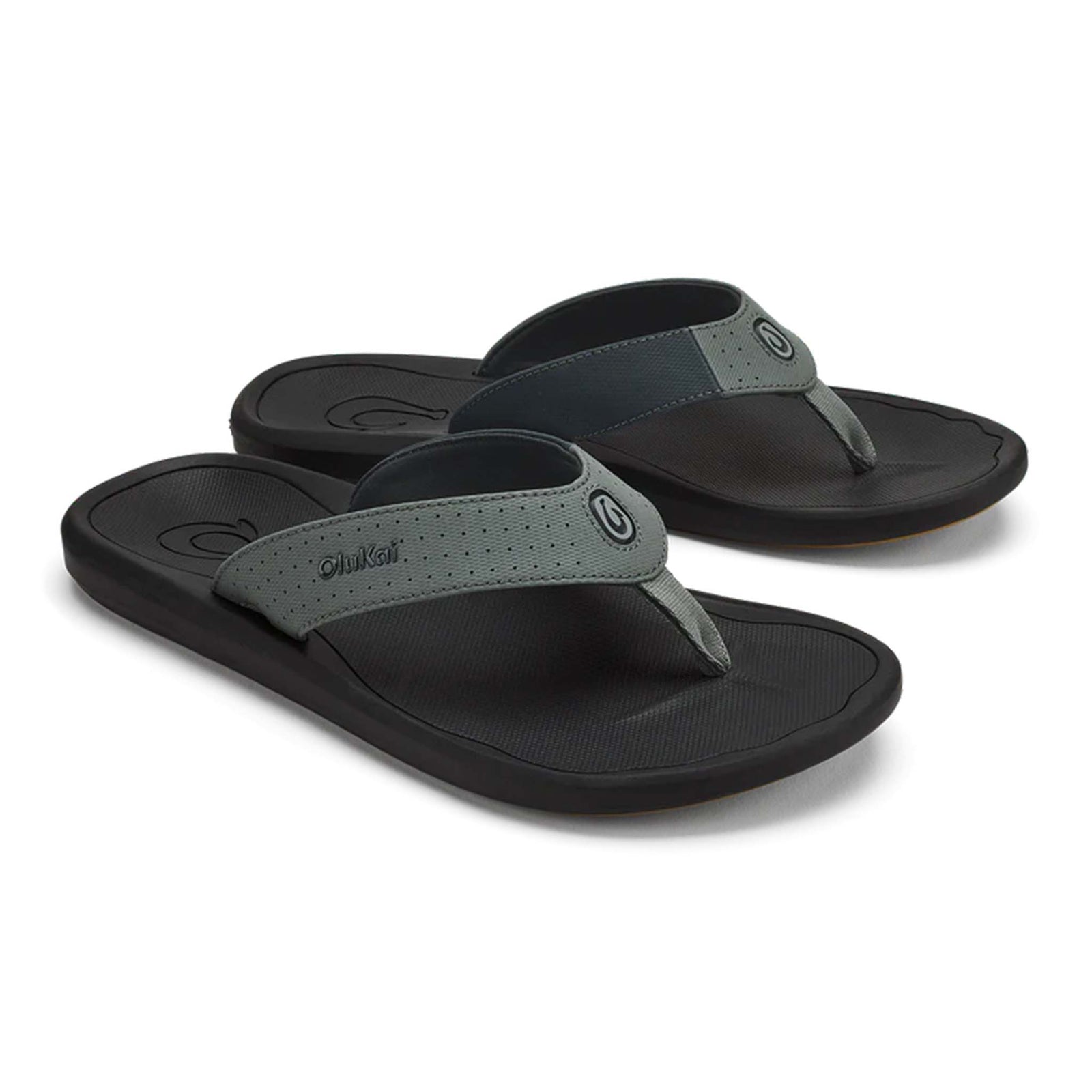 Olukai Men's Ki'i sandal in Lava Rock, size 9, 10, 11, 12, 13.
Angled view of a pair of Olukai Kiʻi sandals in Lava Rock with dark soles and wide perforated dark gray straps, shown side by side on a white background.
 Water-Friendly and Durable
Steady Traction
Airy Perforated Straps