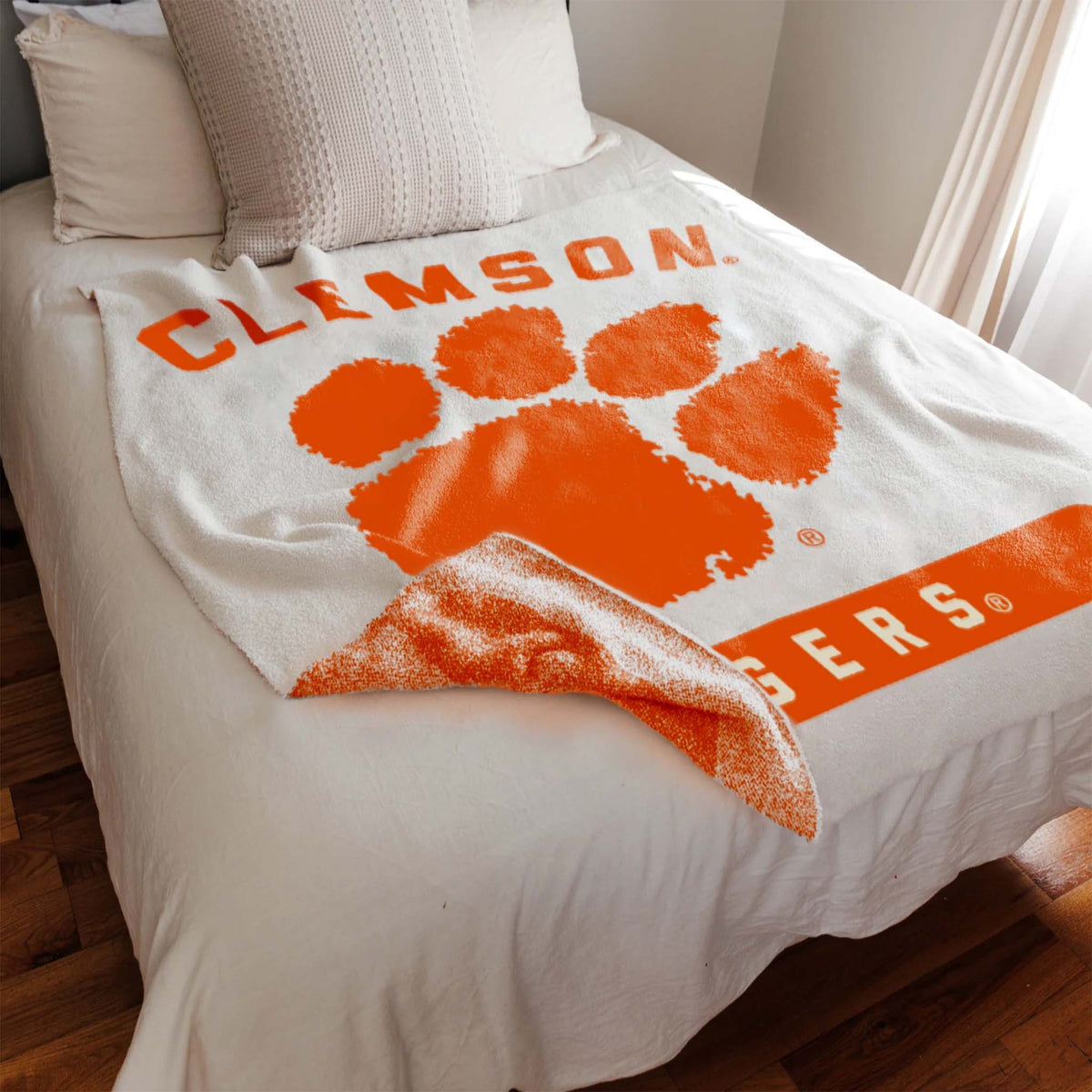 Clemson Tigers blanket draped over a bed in a bedroom setting