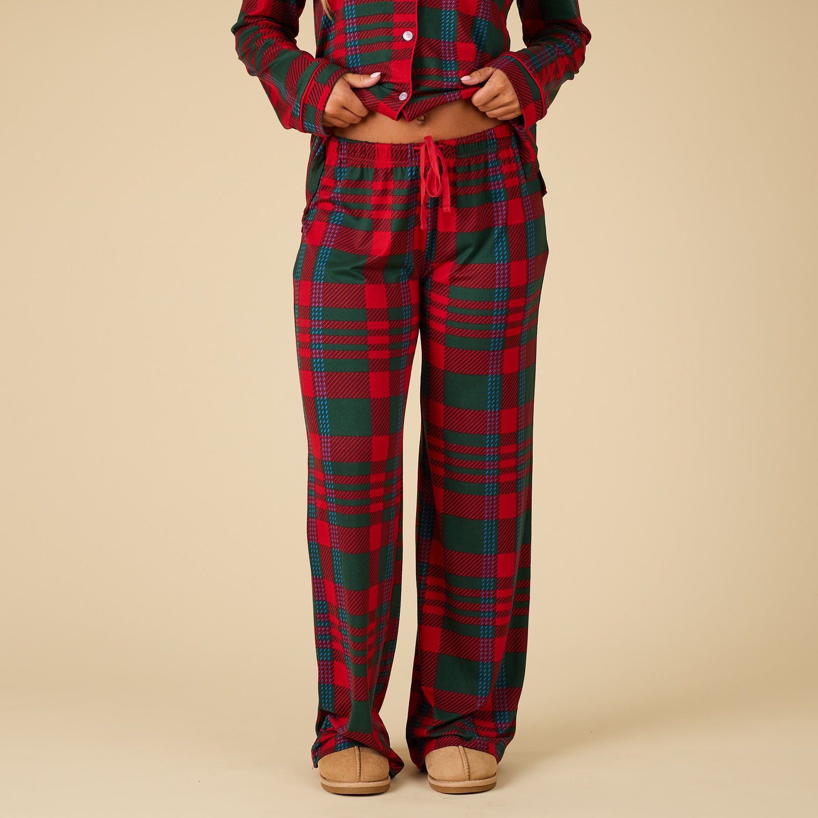 Red and green plaid pajama set on a beige background