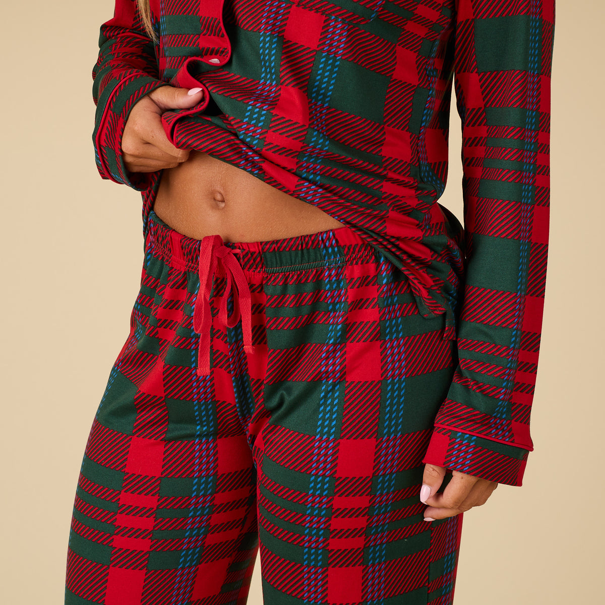 Red and green plaid pajama set on a beige background