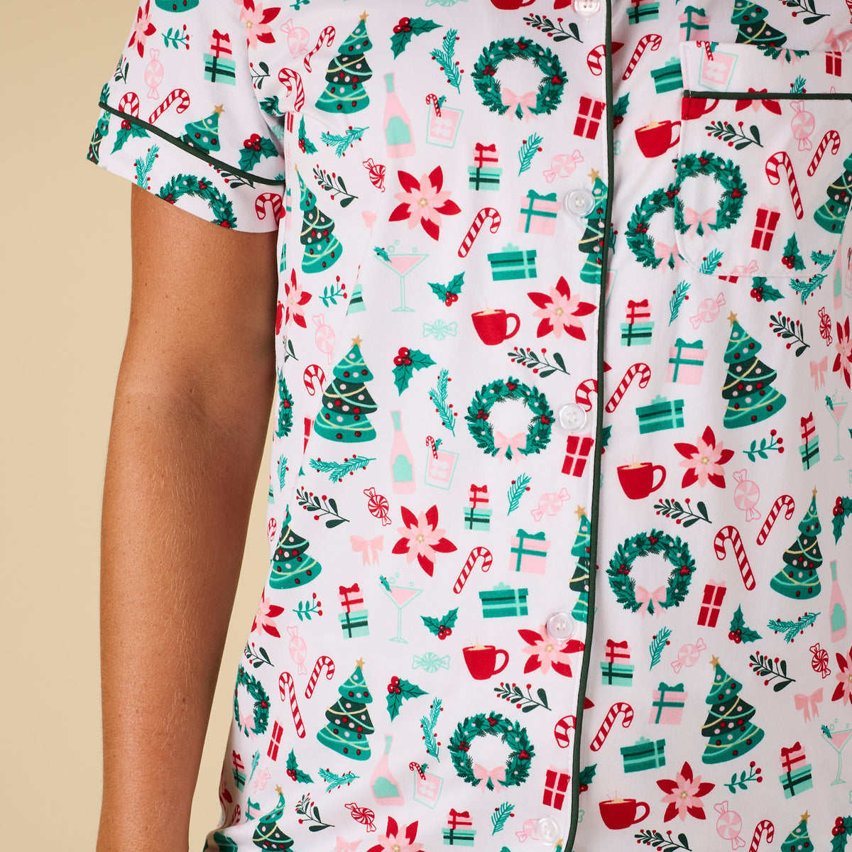 Close up detail shot of Christmas printed pajamas with wreaths, mugs, holiday florals, and gifts.