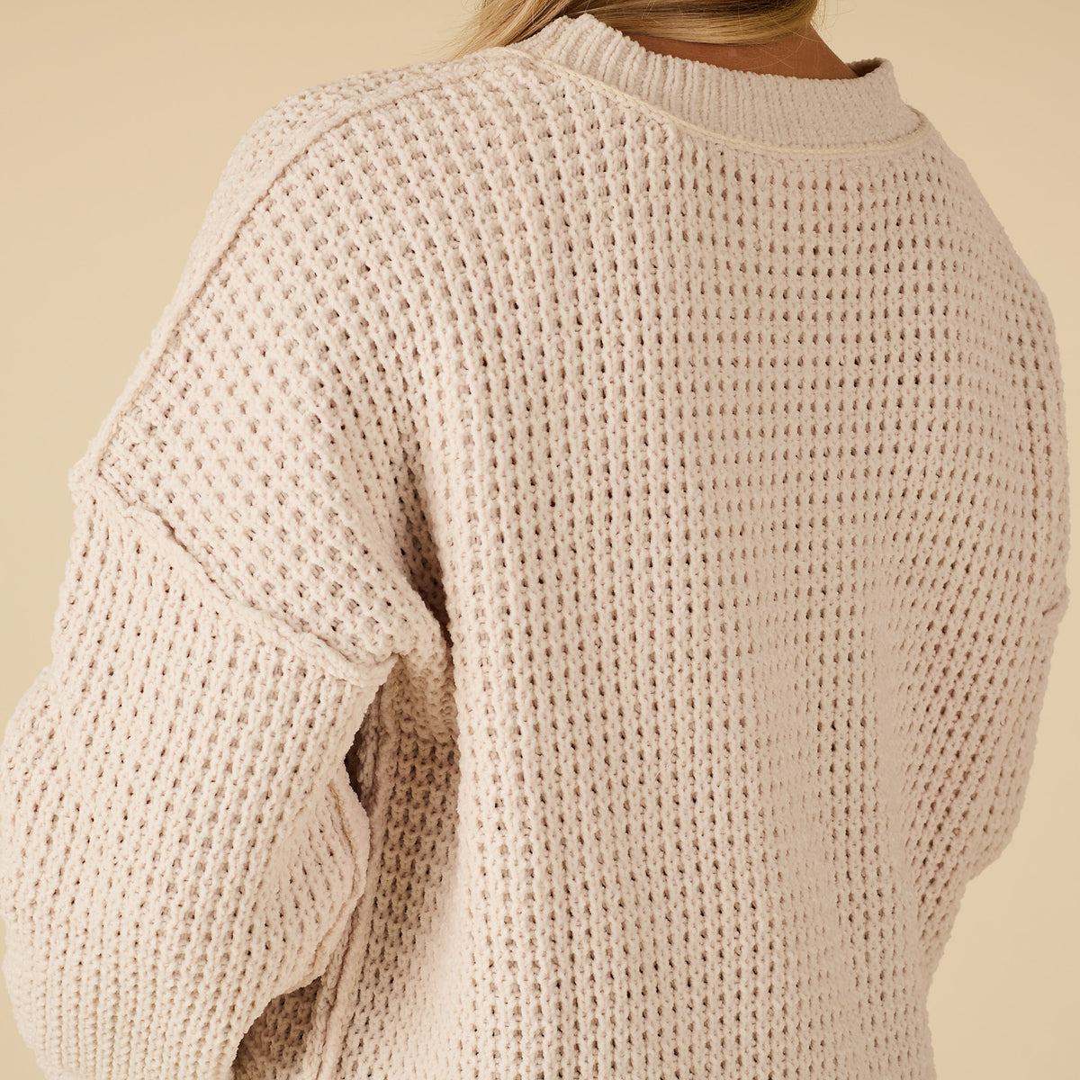 Beige knitted sweater on a beige background