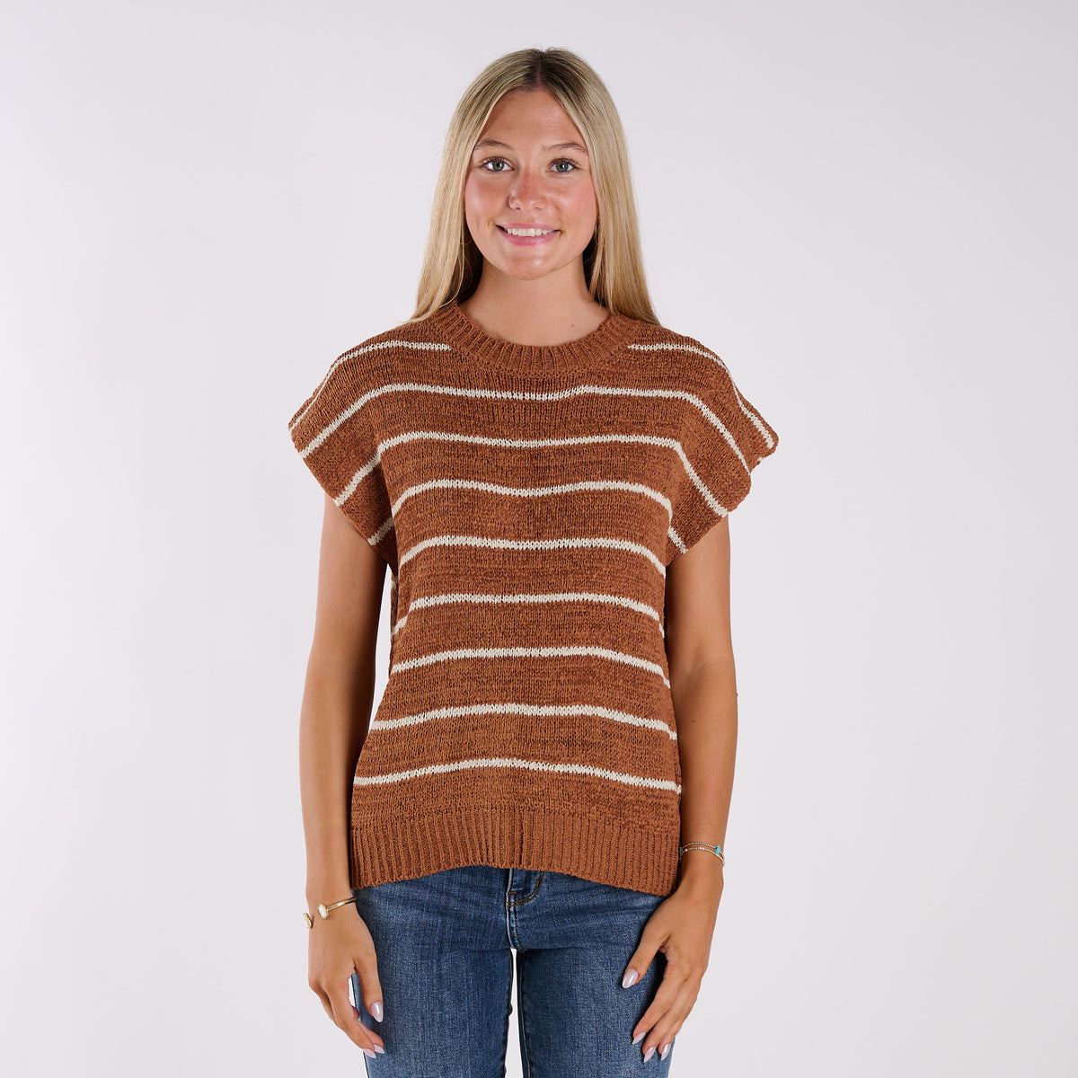 Woman wearing a brown and white striped sweater on a white background