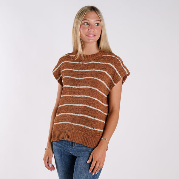  Woman wearing a brown and white striped sweater against a plain background