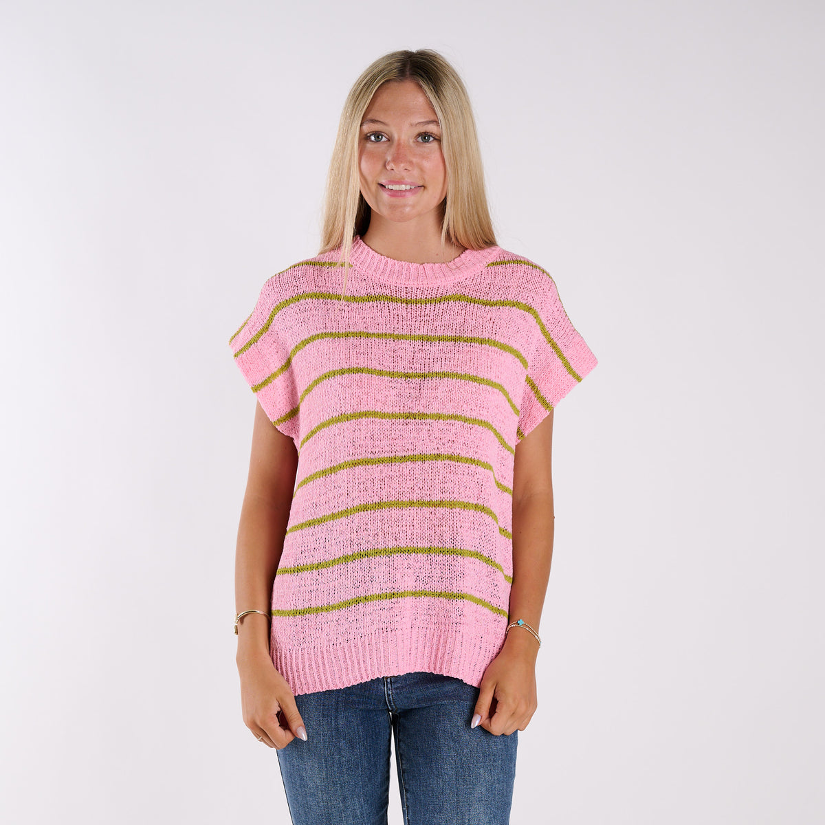 Woman wearing a pink and green striped sweater against a white background