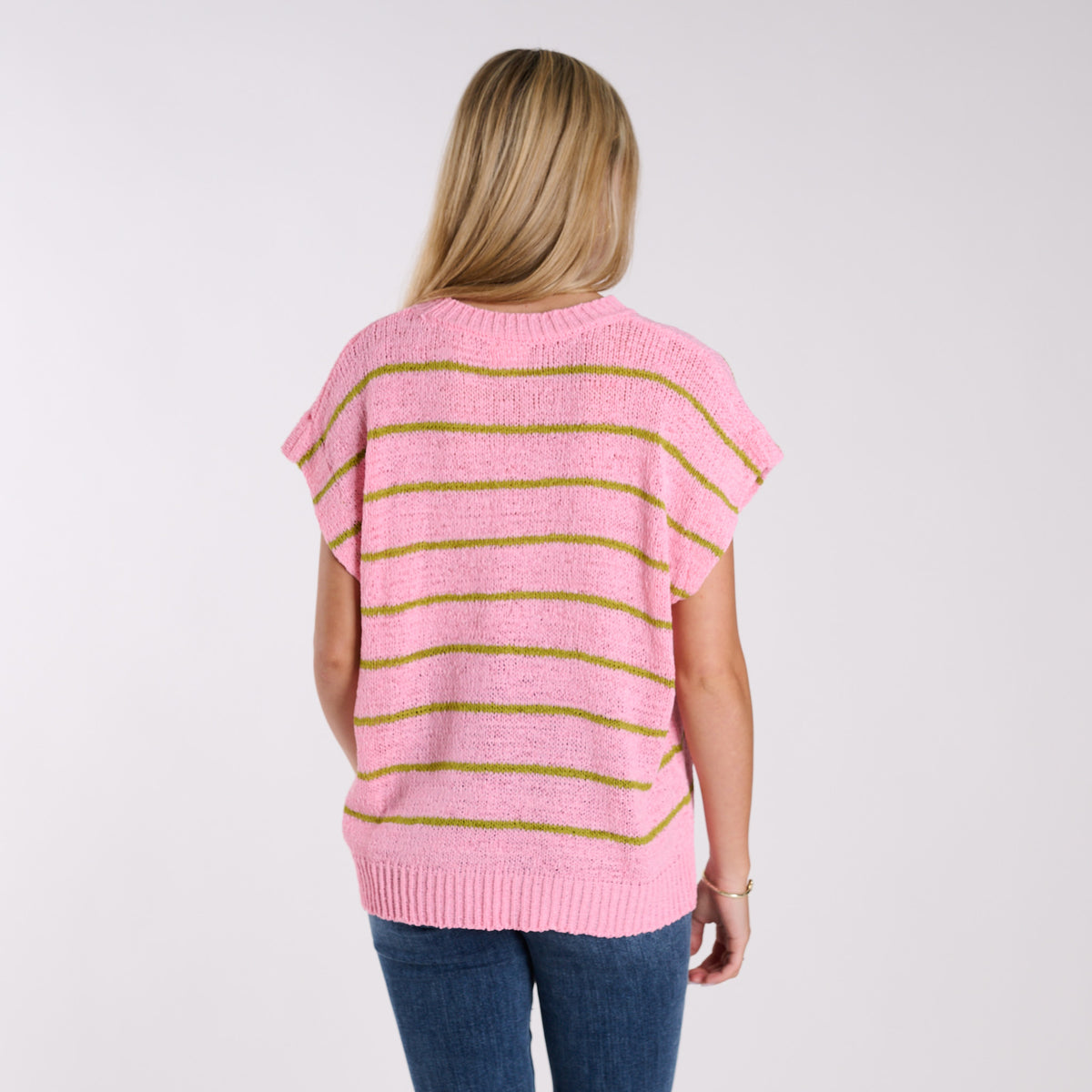 Person wearing a pink striped sweater on a plain background