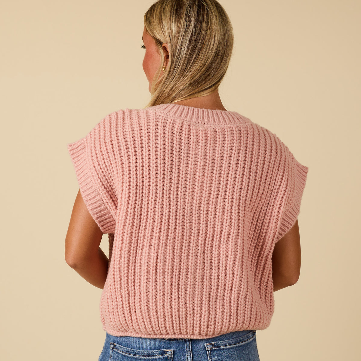 Back view of women’s blush chunky knit short sleeve top with ribbed texture and relaxed fit.
