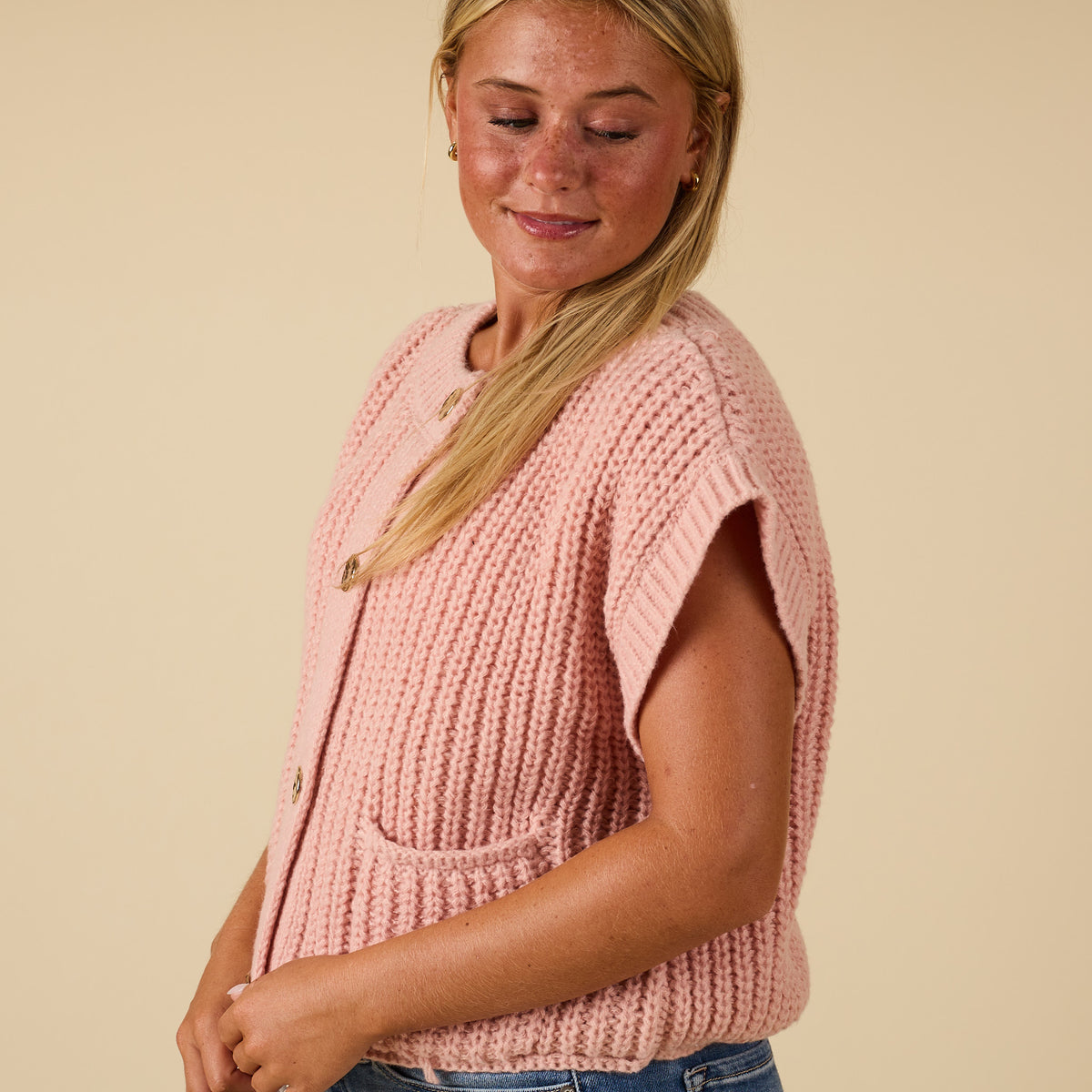 Side view of women’s blush chunky knit button-front top with front pocket and relaxed sleeves.