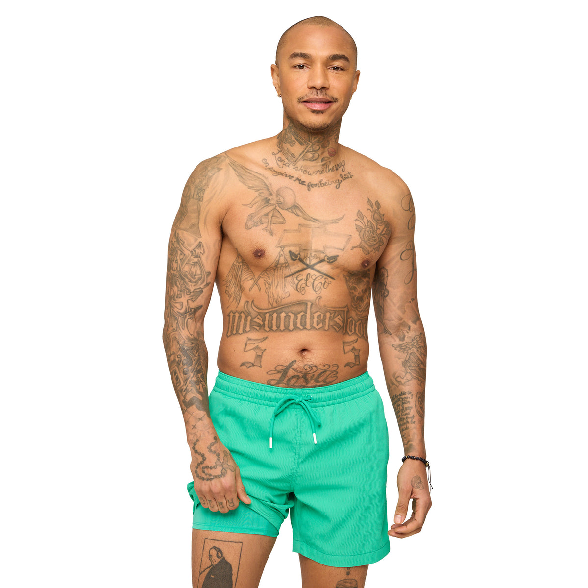 Man wearing teal Chubbies swim shorts standing in front of a white background