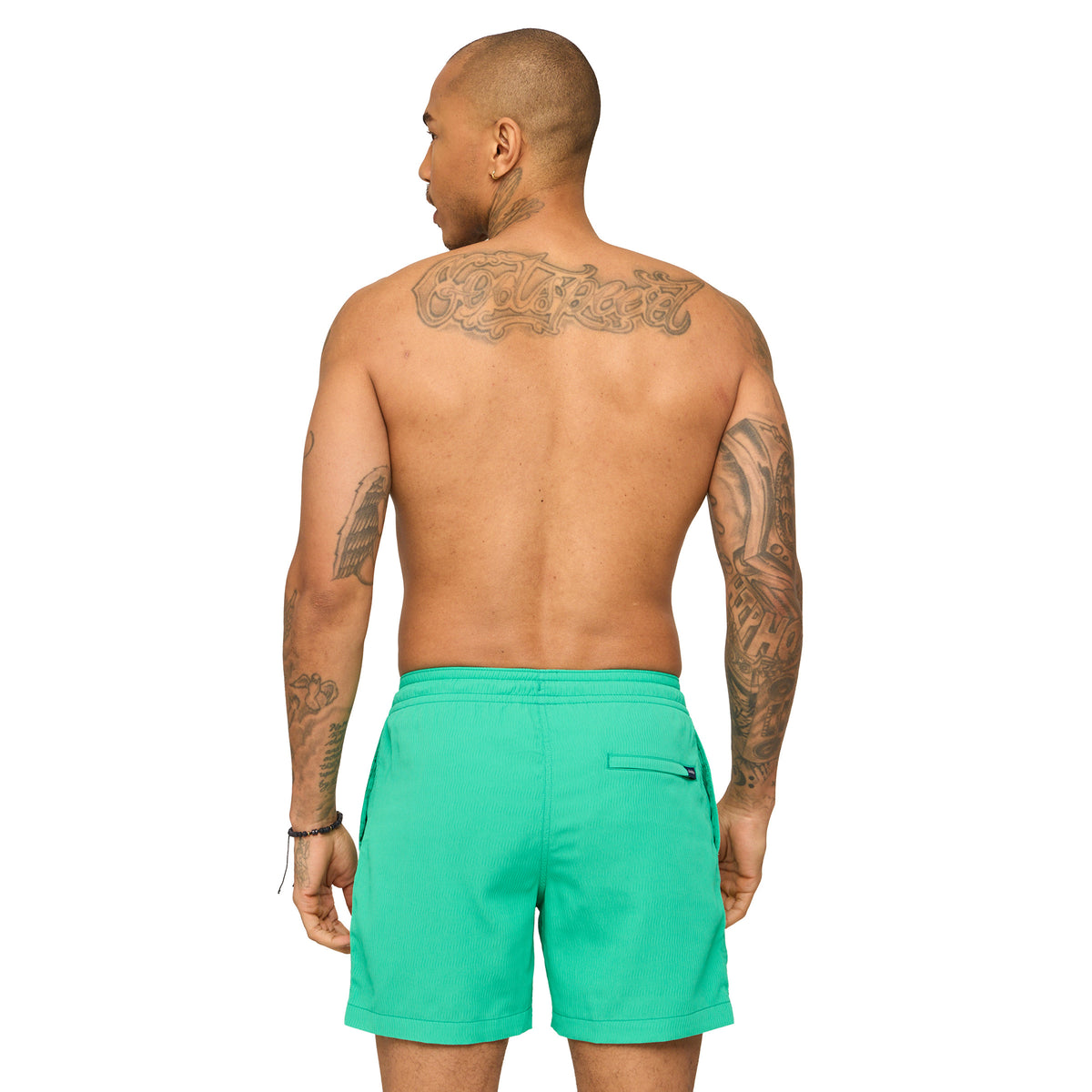 Man wearing teal Chubbies swim shorts standing in front of a white background