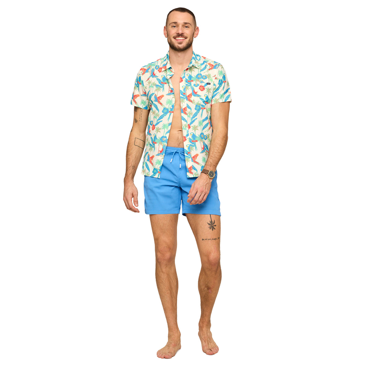 Man wearing a colorful patterned shirt and blue Chubbies swim shorts on a white background
