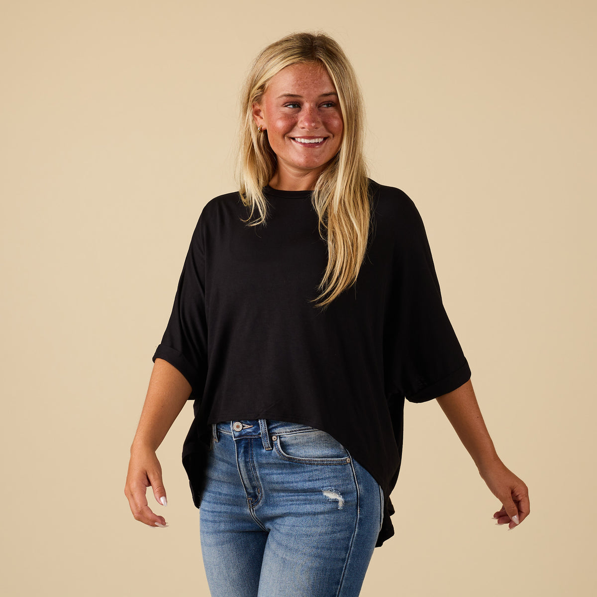 Model wearing hi lo black short sleeve top with relaxed fit, shown from front
