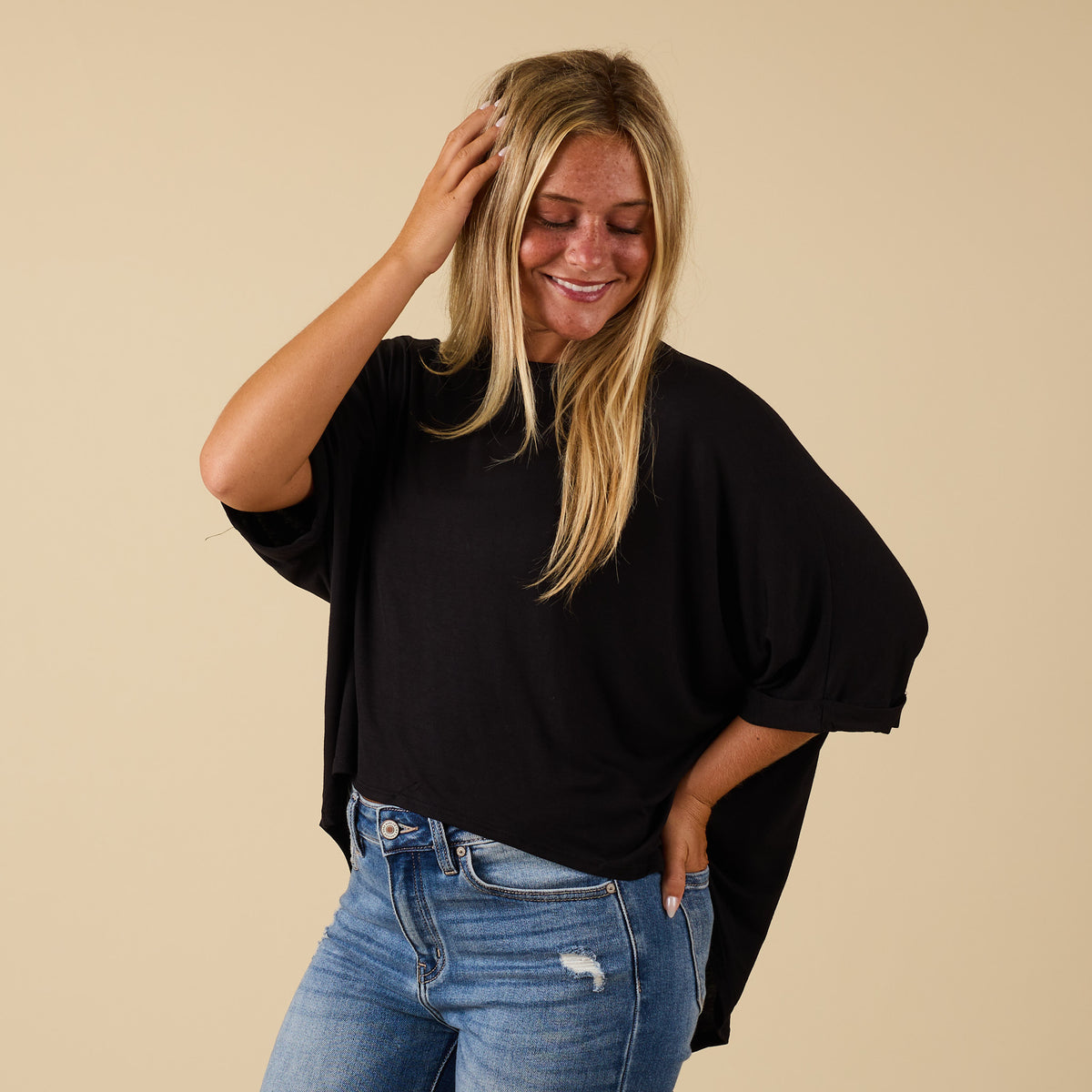 Model wearing hi lo black short sleeve top with relaxed fit, shown from front