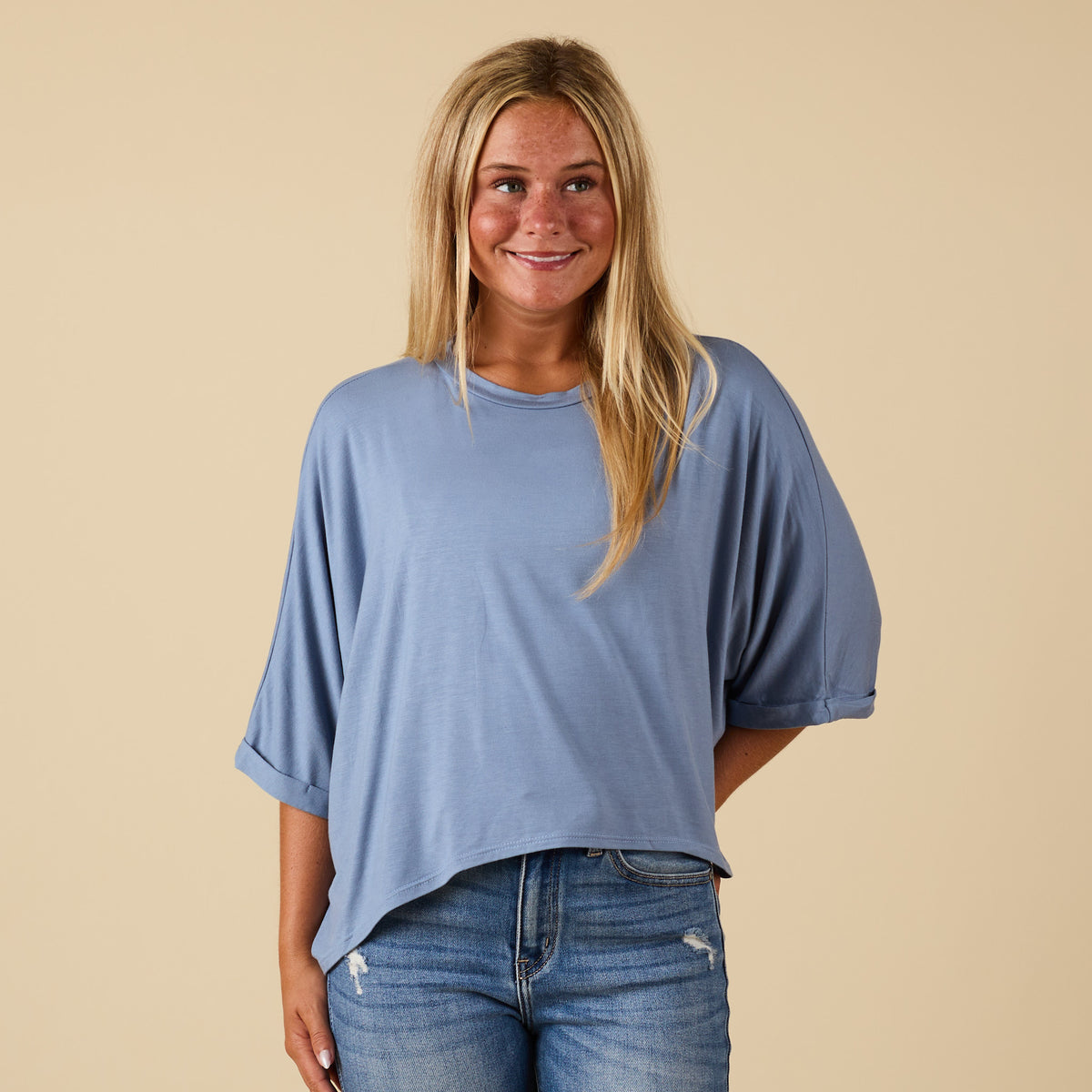 Model wearing hi lo denim blue short sleeve top with relaxed fit, shown from front