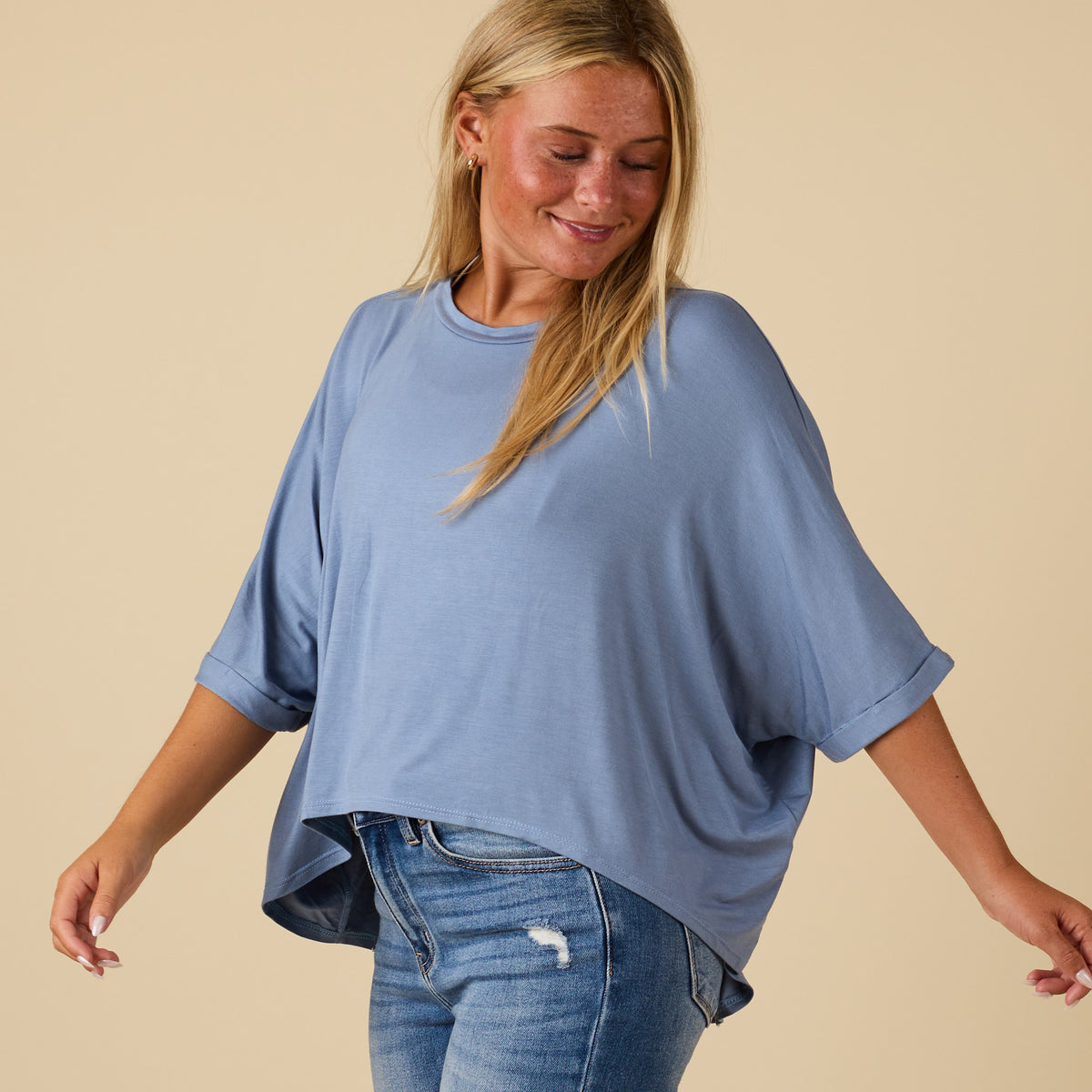 Model wearing hi lo denim blue short sleeve top with relaxed fit, shown from side