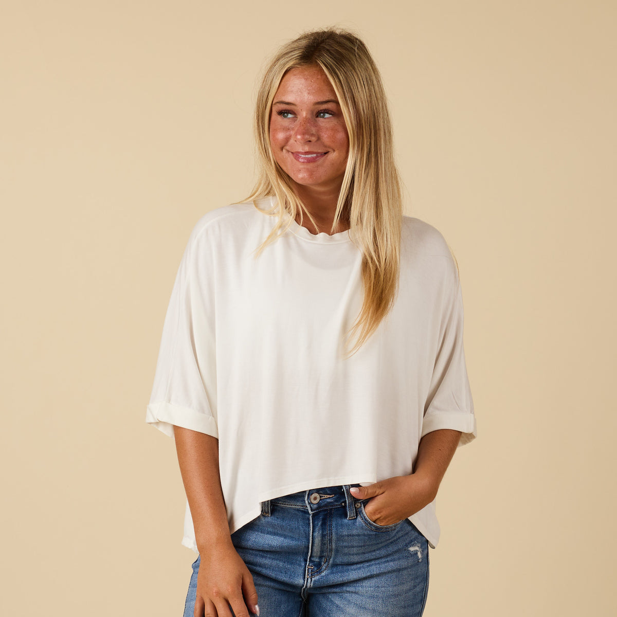 Model wearing hi lo white short sleeve top with relaxed fit, shown from front 