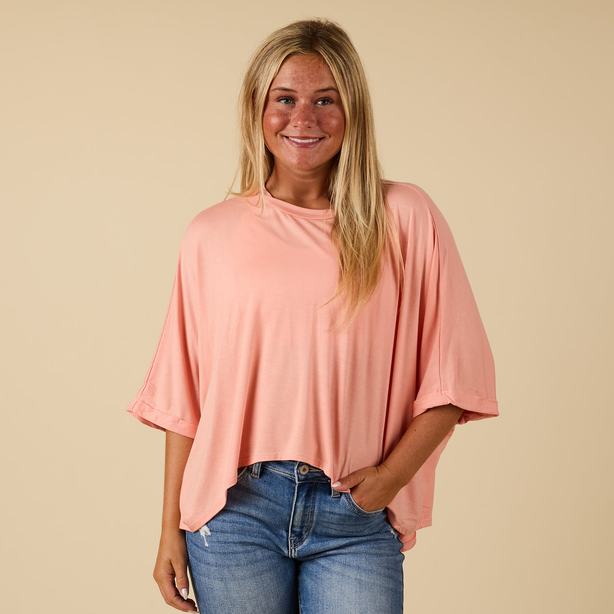 Model wearing hi lo peach short sleeve top with relaxed fit, shown from front 