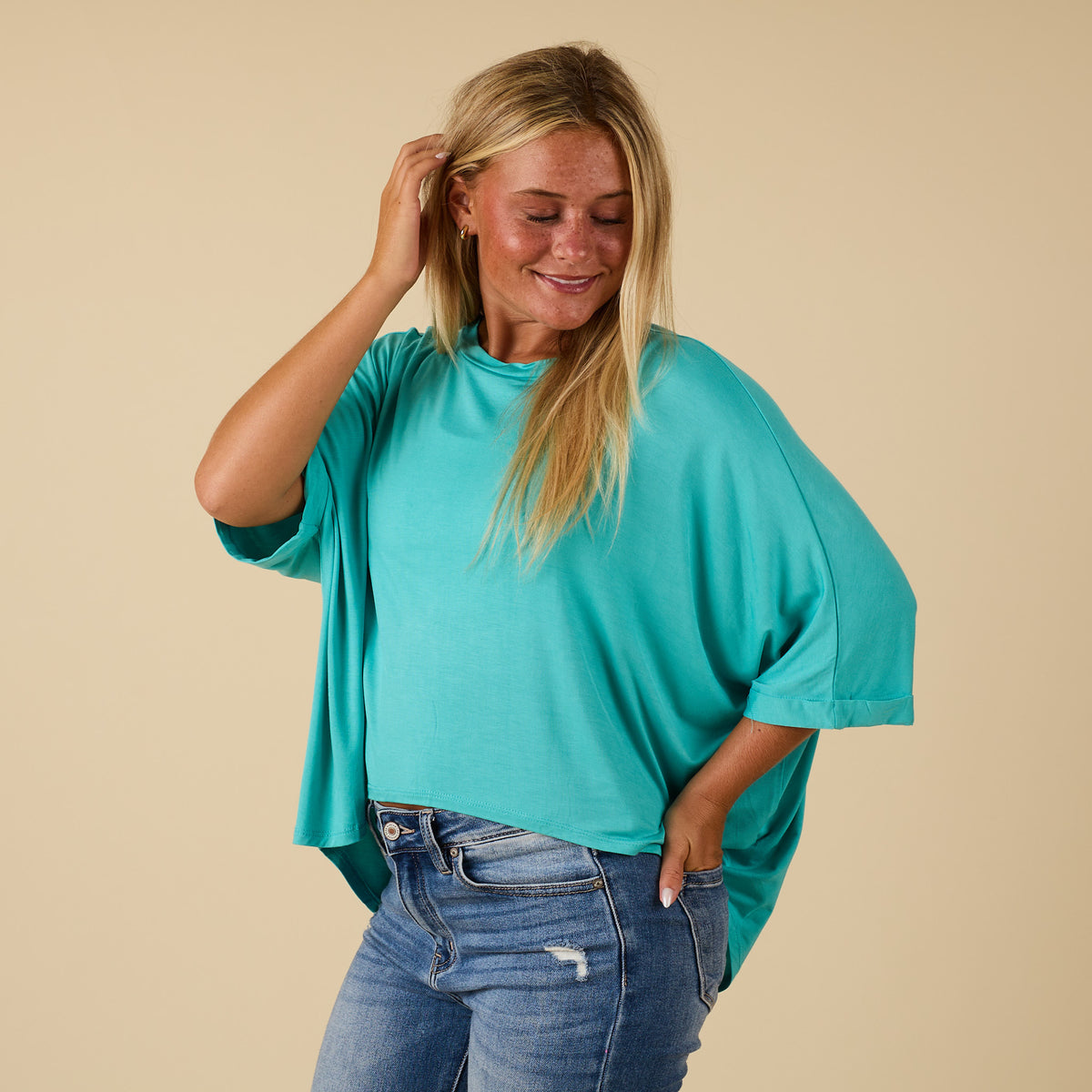 Model wearing hi lo seafoam short sleeve top with relaxed fit, shown from side 