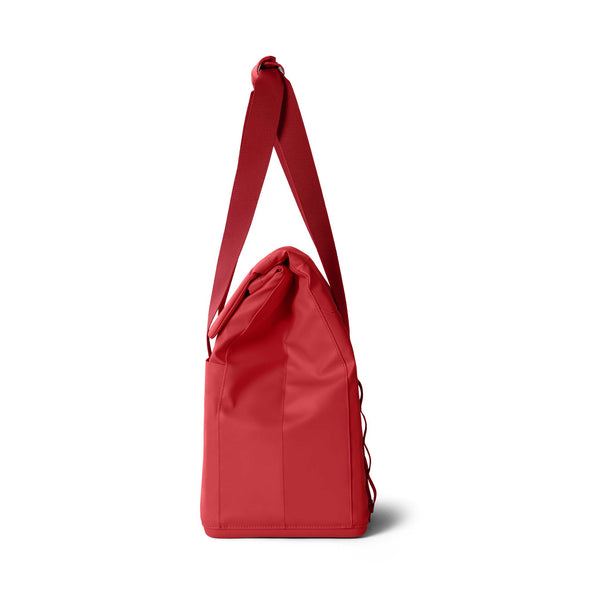Side view of the YETI Daytrip 14L Tote Bag in Rescue Red with the shoulder strap extended upward.