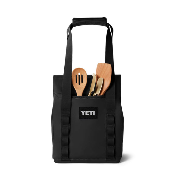 YETI Daytrip 14L Tote Bag in Black - Front view of the tote standing upright with cooking utensils visible in the front pocket.