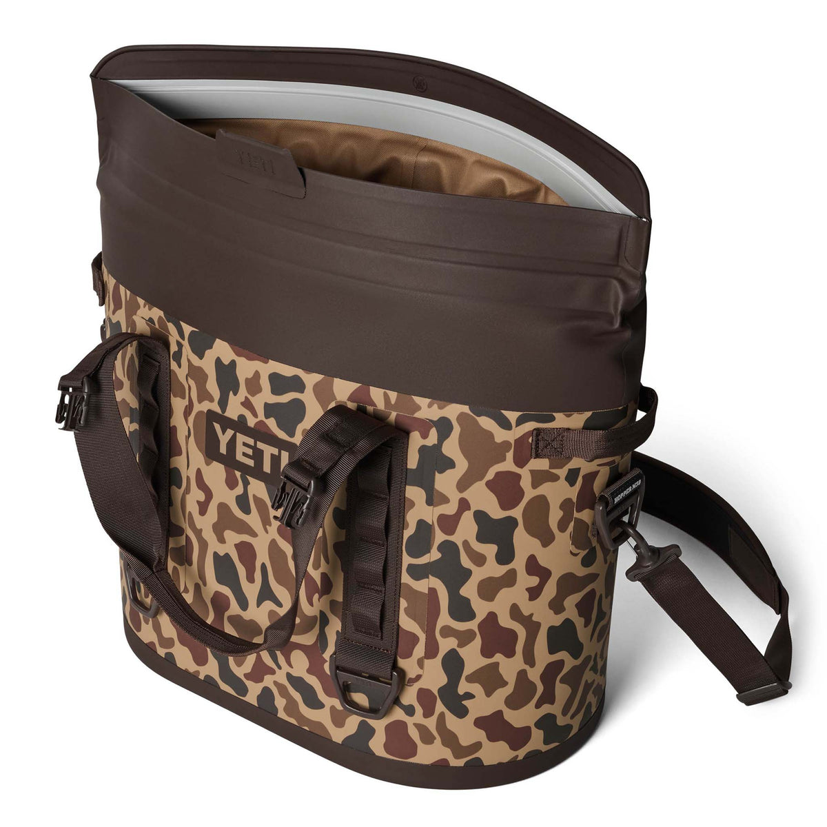 Three-quarter view of YETI Hopper M30 2.0 in Wetlands Camo with shoulder strap and top handles visible.