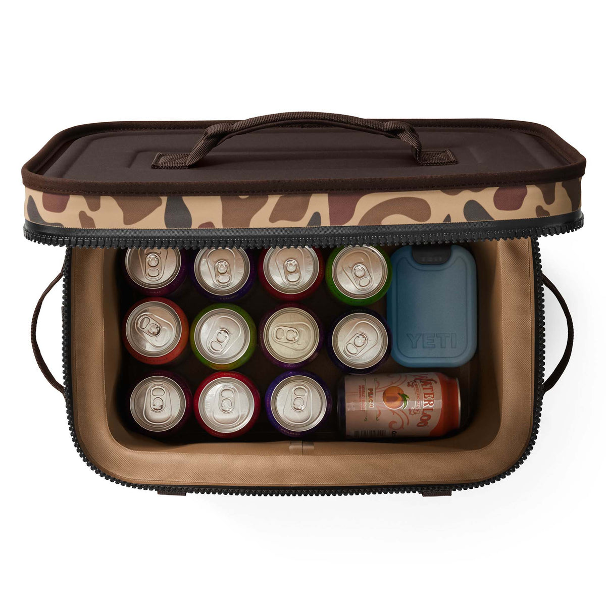 Overhead view of the YETI Hopper Flip 18 in Wetlands Camo packed with assorted canned drinks and a YETI ice pack inside.