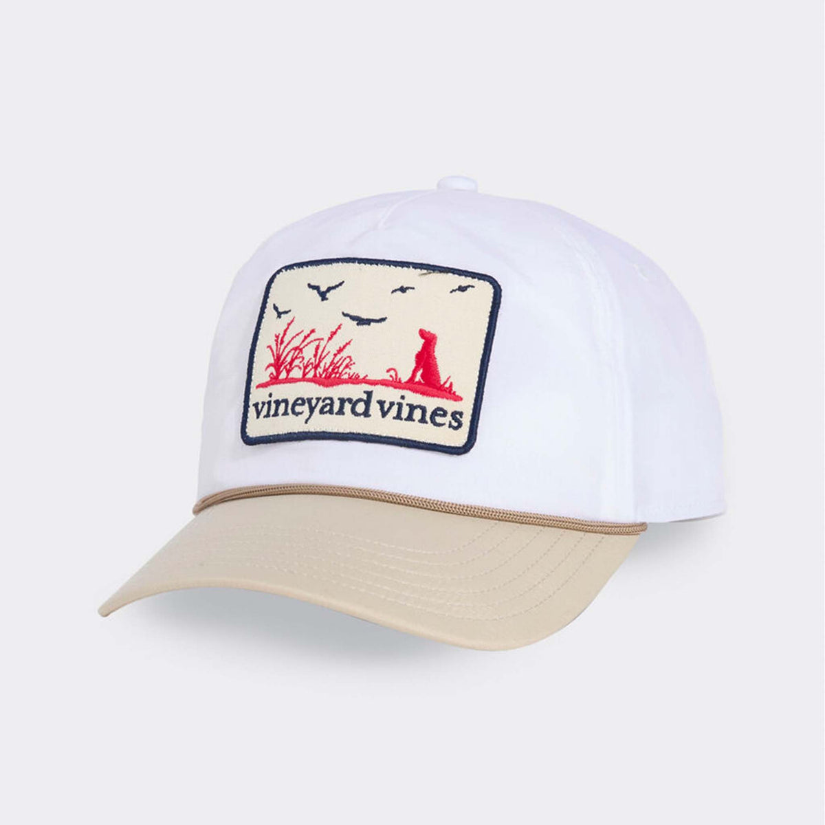 Vineyard Vines Dog Patch Trucker Hat in Stone with white crown, tan bill, and embroidered outdoor scene patch on front.