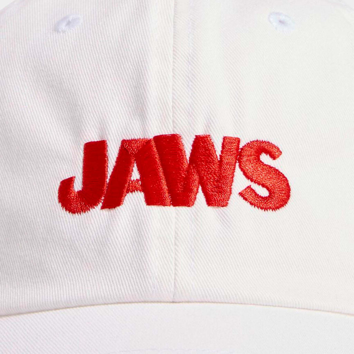 Close-up of the white Vineyard Vines cap featuring red embroidered “JAWS” text in bold letters on the front.
