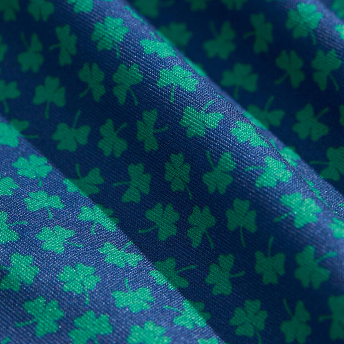 Vineyard Vines On-The-Go Sankaty Polo in Micro Clover Moonshine fabric close-up showing textured performance material with green micro clover design.